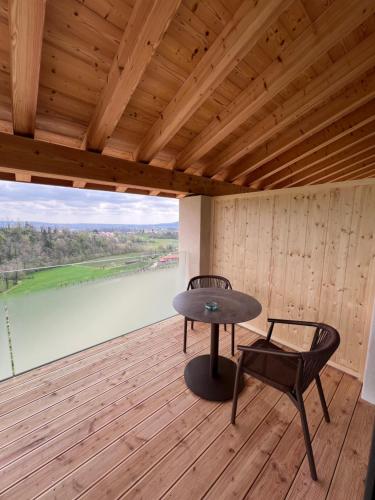 a table and chairs on a deck with a view of a river at Agriturismo Vedova in Valdobbiadene