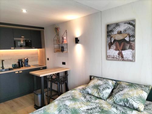 un salon avec un canapé et une cuisine dans l'établissement Studio Zen et Bois, à Écouflant