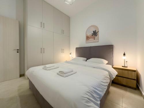 a bedroom with a large white bed with two towels on it at Glenvar Heights I1 90 sqm apt in Paleo Faliro in Athens