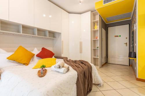 ein Schlafzimmer mit einem großen weißen Bett mit bunten Kissen in der Unterkunft Casa Carlyta - Vicino Ospedale San Raffaele e Metro M2 in Vimodrone