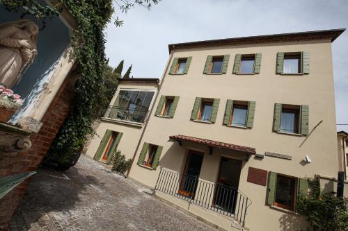 a building on a street next to an alley at La Giuggiola in Arqua Petrarca