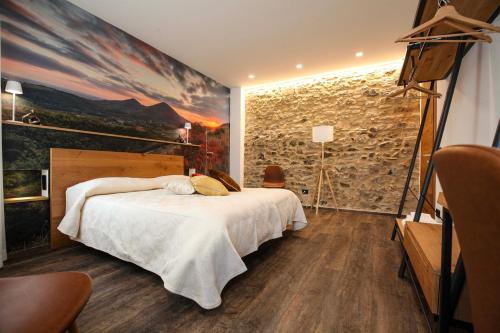 Habitación con cama y pared de piedra. en La Giuggiola en Arqua Petrarca
