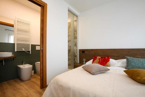 a bedroom with a white bed and a mirror at La Giuggiola in Arqua Petrarca