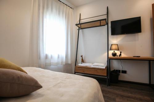 a bedroom with a bed and a flat screen tv at La Giuggiola in Arqua Petrarca