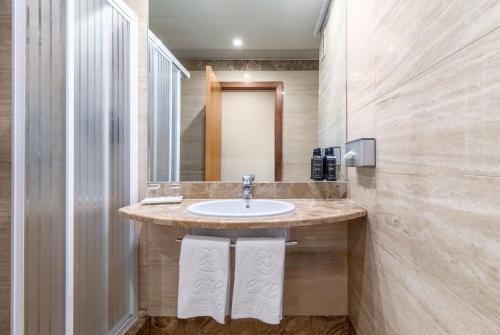 uma casa de banho com um lavatório e um espelho em Exe Pozuelo em Pozuelo de Alarcón