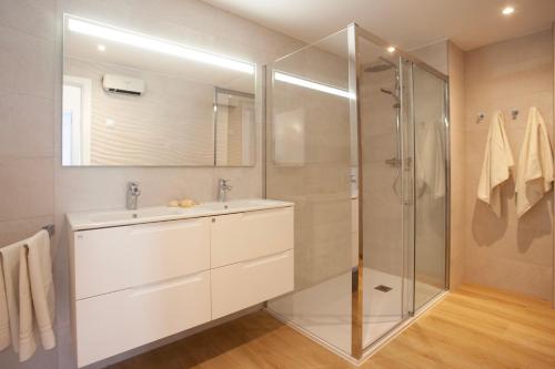 La salle de bains est pourvue d'un lavabo et d'une douche. dans l'établissement Apartaments Edificio Puerto, à Colonia Sant Jordi