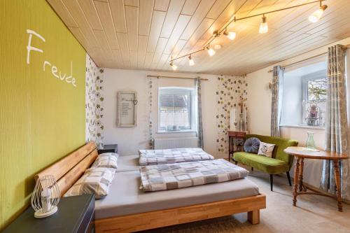 ein Zimmer mit 2 Betten und einem Stuhl darin in der Unterkunft Ferienhaus em Biehl in Frankenhofen