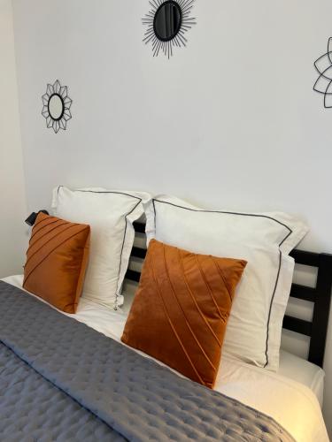 - un lit avec des oreillers blancs et bruns dans l'établissement Luxe et Détente Près du Luxembourg, 
