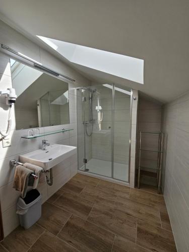 a bathroom with a shower and a sink and a mirror at Appartements Monuth in Bad Hofgastein