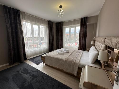 キュタヒヤにあるViyana Premium Pansiyonのベッドルーム1室(大型ベッド1台、窓2つ付)