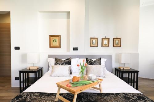 a bedroom with a white bed with a table on it at Affittacamere CA'STELLA La Morra centro in La Morra