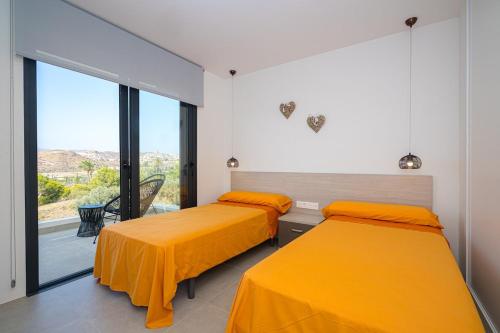 two beds in a room with yellow sheets at Barzinu - Isla del Fraile in Águilas