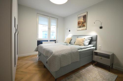 a bedroom with a bed and a window at Wilcza City Center Apartments in Gdańsk