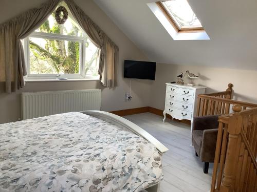 um quarto com uma cama, uma televisão e uma janela em Byre Cottage em Alston