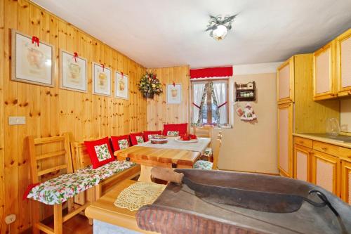eine Küche mit Holzwänden sowie einem Tisch und Stühlen in der Unterkunft Casa Betulla Champorcher in Champorcher