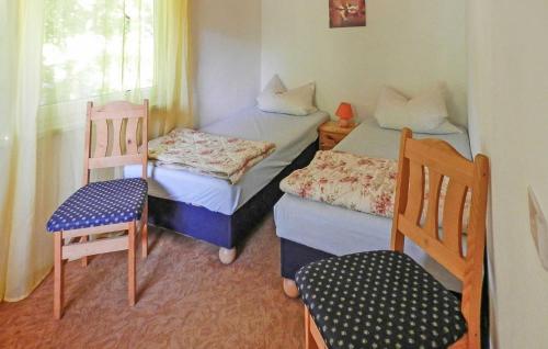 a small room with two beds and a chair at 2 Bedroom Cozy Home In Boitzenburger Land in Rosenow