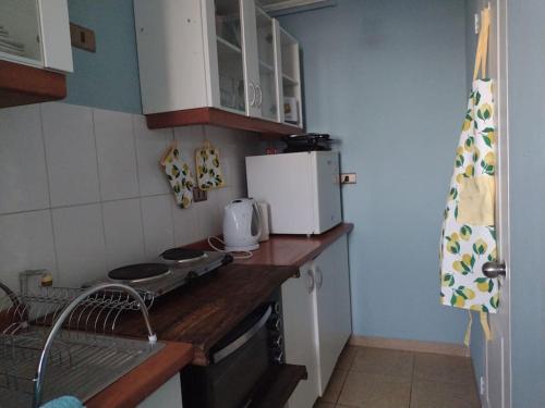 y cocina con encimera, fogones y microondas. en Cómodo Departamento, en Los Ángeles