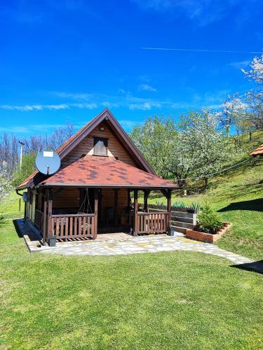 a house with a gazebo in the grass at Brvnara na bregu in Bajina Bašta