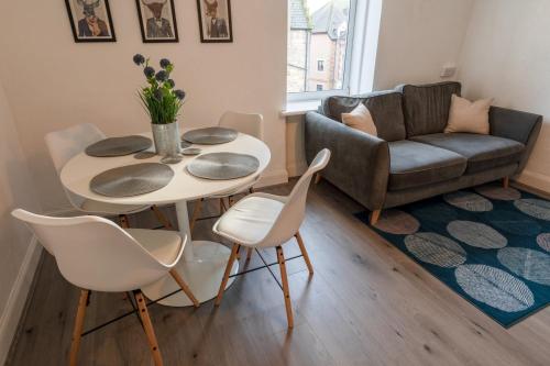 a living room with a table and chairs and a couch at Riverside Flat in Inverness