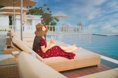 uma mulher sentada numa cadeira ao lado de uma piscina em Mawseintyllang Resort em Shillong