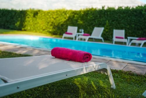 - une serviette rouge assise sur une table à côté d'une piscine dans l'établissement Villa Leko Dream House, à Cetina