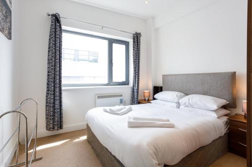 a bedroom with a large bed and a window at GuestReady - Apt perto do centro da cidade in Liverpool