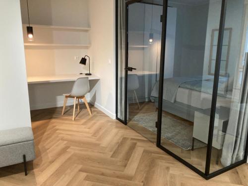 a room with a desk and a bed and a mirror at Wilcza City Center Apartments in Gdańsk