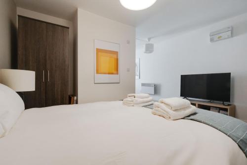 Un dormitorio con una cama blanca con toallas. en GuestReady - Quaint Liverpool Gem en Liverpool