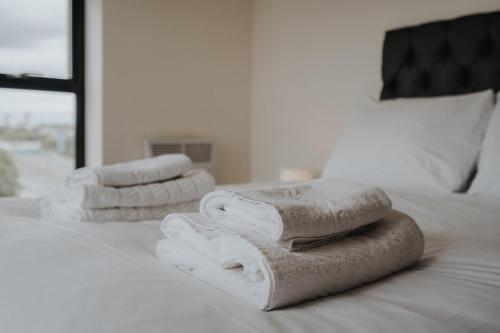 uma pilha de toalhas sentadas em cima de uma cama em GuestReady - An enjoyable stay in Vauxhall em Liverpool