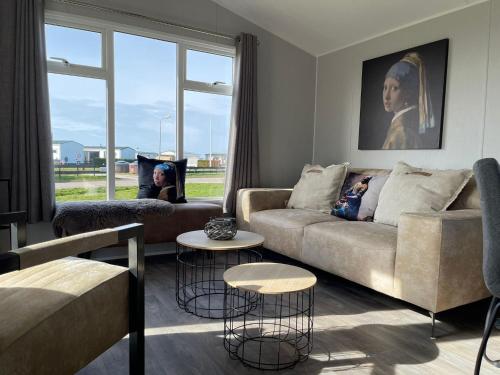 sala de estar con sofá y 2 mesas en Neues Ferienhaus Nr 47 mit Meerblick 100 Meter zum Wattenmeer, eingezäunt, hundefreundlich, en Westerland