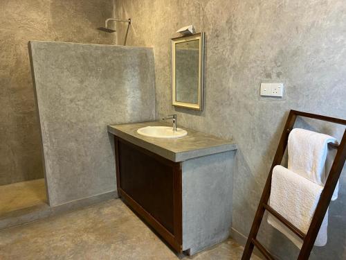 a bathroom with a sink and a mirror at Par 5 Golf Villa in Digana