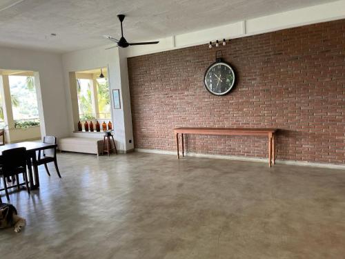 a room with a brick wall and a clock on the wall at Par 5 Golf Villa in Digana