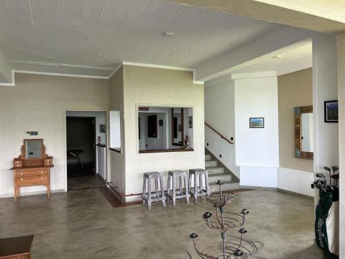 a room with chairs and a table and a desk at Par 5 Golf Villa in Digana