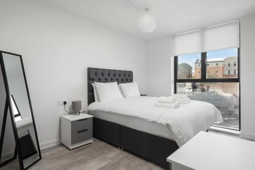 a white bedroom with a large bed and a window at GuestReady - Conforto de luxo em Liverpool in Liverpool