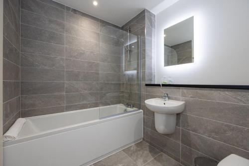 a bathroom with a tub and a sink and a toilet at GuestReady - Liverpool's best near World Museum in Liverpool