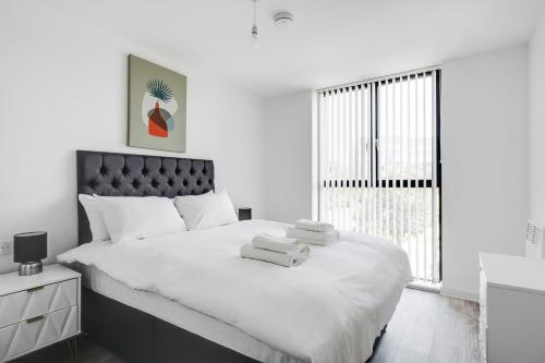 a white bedroom with a large bed with towels on it at GuestReady - A lovely hideaway in Vauxhall in Liverpool