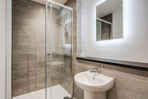 a bathroom with a sink and a glass shower at GuestReady - A lovely hideaway in Vauxhall in Liverpool