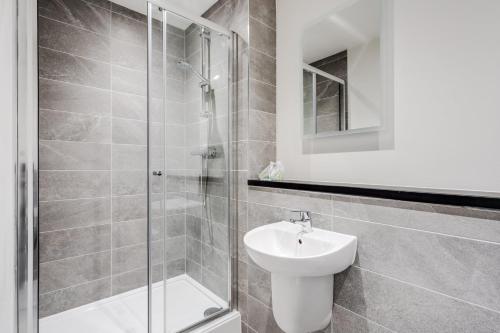 een badkamer met een douche, een toilet en een wastafel bij GuestReady - Comforting city retreat in Vauxhall in Liverpool