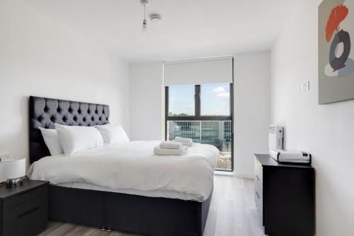 een witte slaapkamer met een groot bed en een raam bij GuestReady - Comforting city retreat in Vauxhall in Liverpool