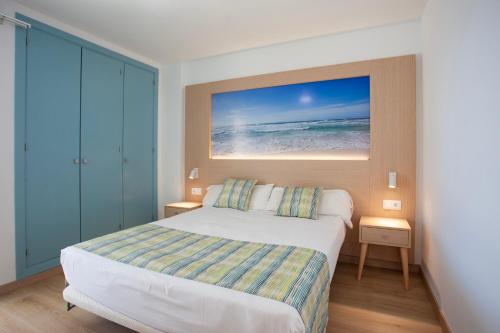 1 dormitorio con 1 cama y una foto del océano en Apartaments Edificio Puerto, en Colonia de Sant Jordi