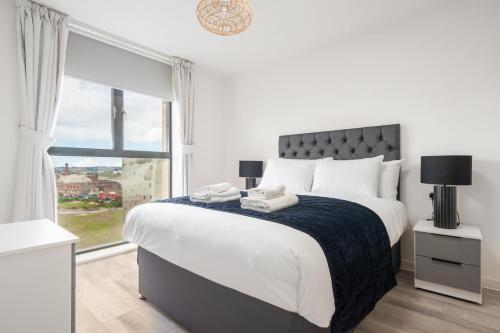 a white bedroom with a large bed and a window at GuestReady - Charming Hideaway in Liverpool in Liverpool