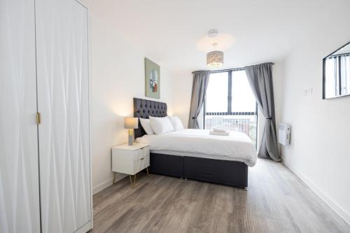 a white bedroom with a bed and a window at GuestReady - Liverpool Adventure near World Museum in Liverpool