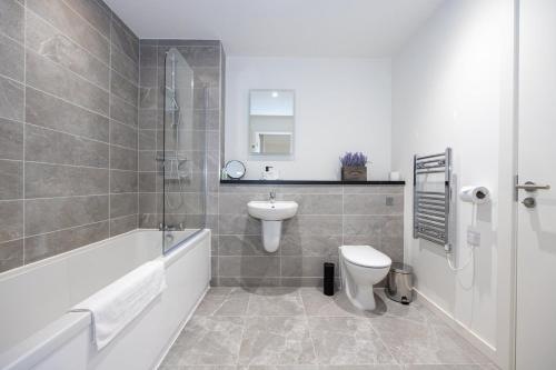 a bathroom with a sink and a toilet and a bath tub at GuestReady - Liverpool Adventure near World Museum in Liverpool