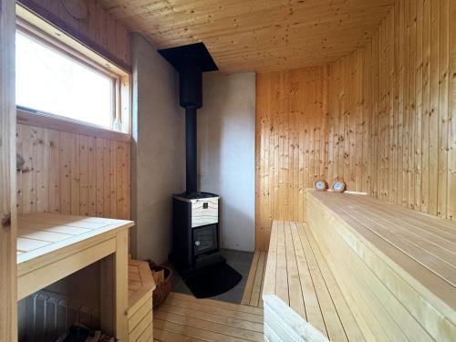 um quarto com um fogão a lenha numa sauna em Historic wilderness cabin near Tystberga em Tystberga