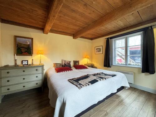 ein Schlafzimmer mit einem Bett, einer Kommode und einem Fenster in der Unterkunft Historic wilderness cabin near Tystberga in Tystberga