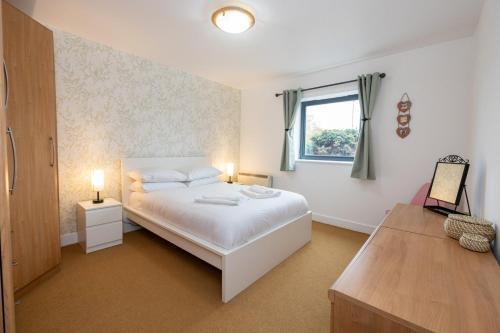 1 dormitorio con cama blanca y ventana en GuestReady - Modern retreat in Liverpool, en Liverpool