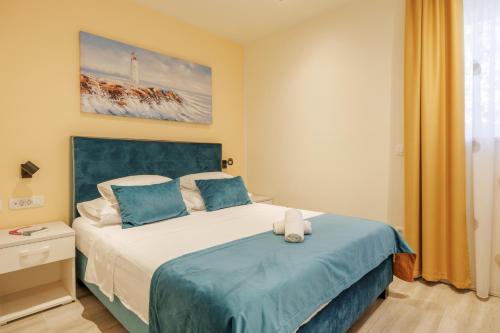 a bedroom with a bed with a blue headboard at Perimar Luxury Apartments and Rooms Split Center in Split