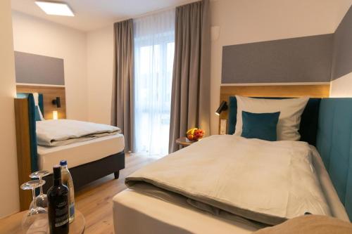 a hotel room with two beds and a window at Gasthaus Karpfinger in Aiterhofen