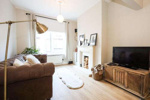 a living room with a couch and a television at GuestReady - Walton's Delight in Liverpool