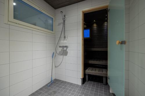 a bathroom with a shower with a bench in it at RUKALODGE - High quality Lodges with saunas and extras. in Ruka